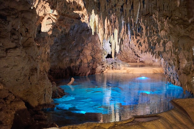Image of an underground cave with beautiful blue water on ground and rocks and stalagmite on top. - Okinawa, Japan - Okinawa, Japan